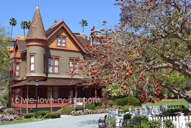 Home has classic victorian design with shingles, the corner tower and a veranda encircling it.
