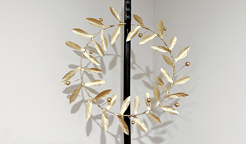 Gold metal wreath on stand