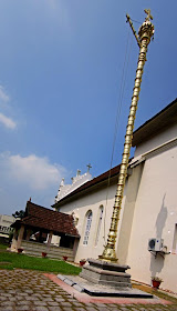 tall gold lamp tower at the entrance to the Kerala ancient church of Cheriya Pally