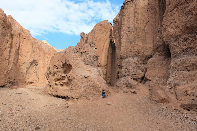 Boy resting in front of dry waterfall