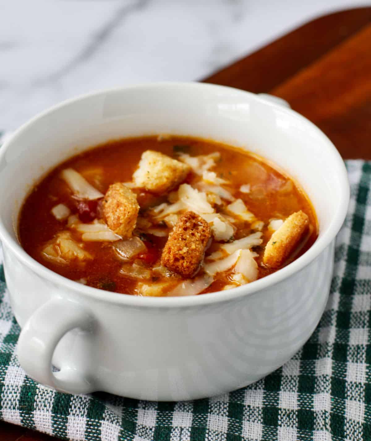 Irish Cod Soup with cheddar in a small white bowl.