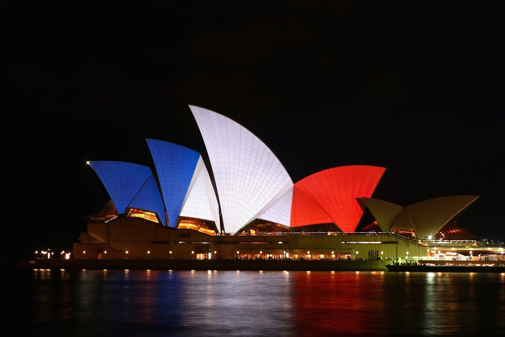 70 Of The Most Touching Photos Taken In 2015 - The One World Trade Center and Sydney Opera House are lit in the blue, white and red colors of the French flag to honor the victims of the November attacks in Paris.