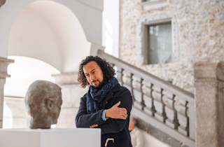 a cultural critic examining a sculpture