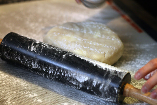 Rolling out the pie dough with a heavy rolling pin