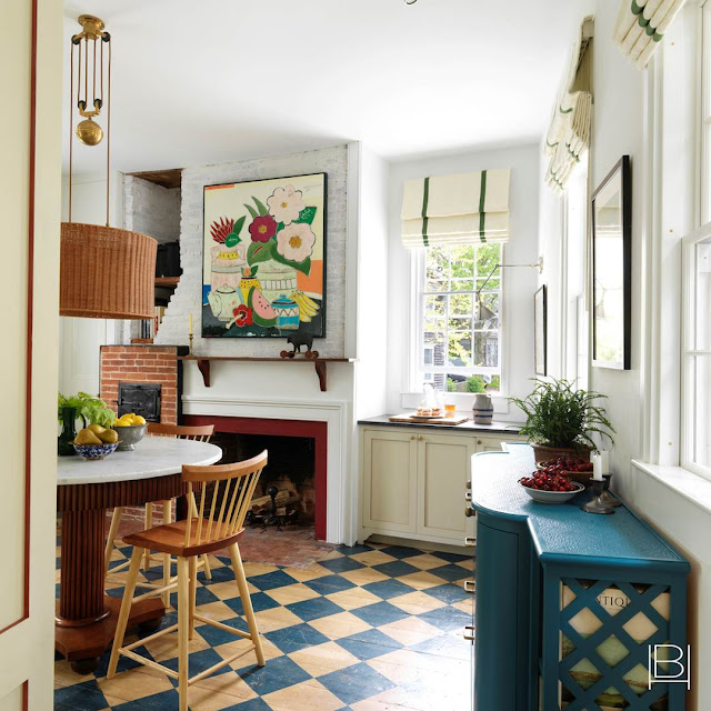Beata Heuman traditional kitchen with blue diamond painted wood floors, oversized rattan pendant light over table, and bright artwork