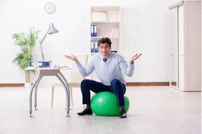 man sitting on gym ball as an office seat