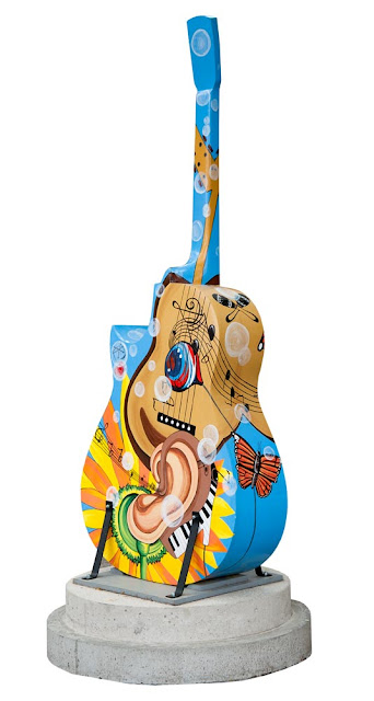 Orillia Painted Guitars downtown, blue guitar with ear and sunflower design