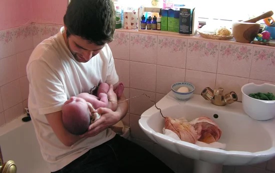 Babai duke mbajtur fëmijën e sapolindur