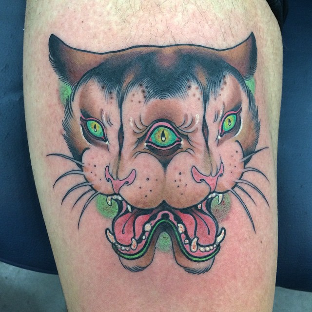 a mirrored cat head with 3 eyes tattoo