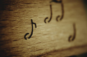 Notas musicais grafadas em madeira
