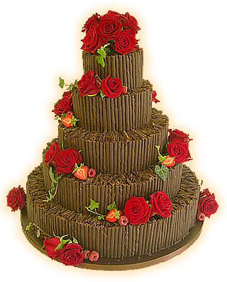 Four tier wedding cake decorated with chocolate cigarillos and fresh bright