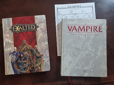 photo of two RPG books: Exalted (a grey and red cover with five heros posed in front) and Vampire: the Masquerade (a grey marbled cover with the title embossed in bold red).