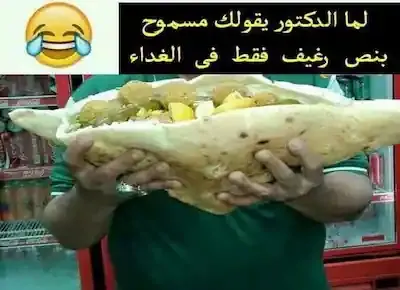 رجل ينتظم على دايت لإنقاص الوزن وهو يحمل بين يديه نصف رغيف ضخم جداً تنفيذاً لأوامر طبيب التخسيس