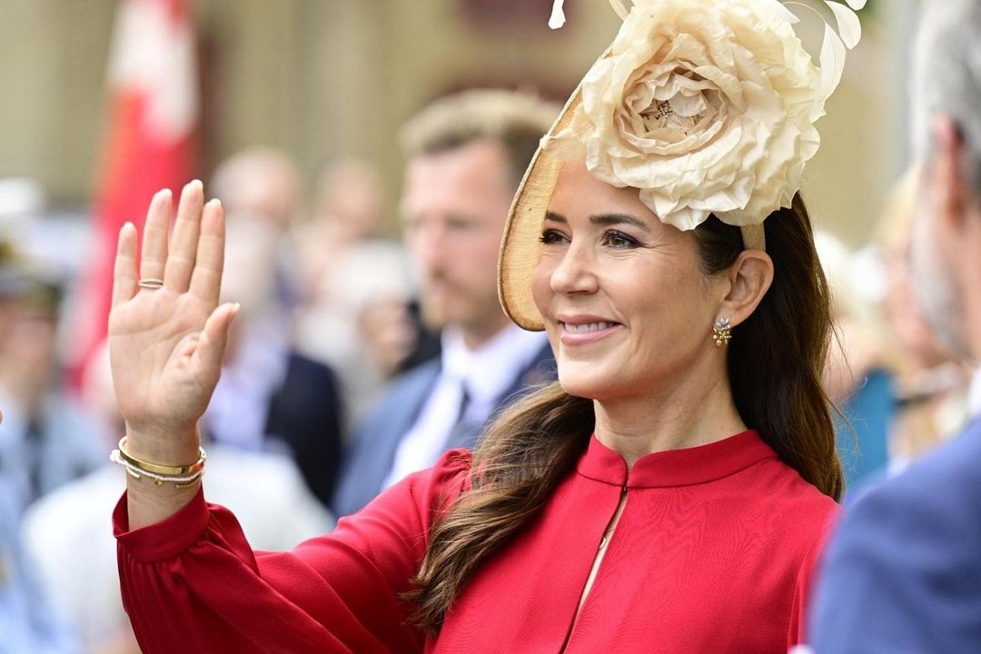 Crown Princess Mary wore her Raquel Diniz dress with her Gianvito Rossi sandals and a repeated clutch. She paired the outfit with her Jane Taylor hat, Ole Lynggaard earrings, and her Julie Sandlau necklace. She also wore her Ole Lynggaard rings with bracelets by Dulong, Ole Lynggaard, and Rebekka Notkin.