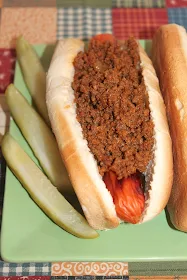 Close-up of a finished hot dog topped with the finished hot dog sauce.