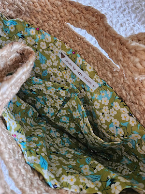 Green floral lining pinned in place in the basket, ready for hand sewing