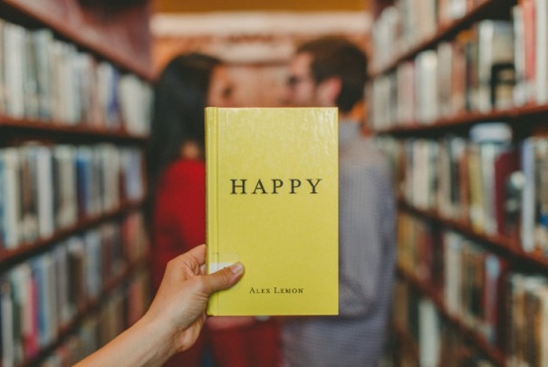 A book on self improvement is displayed against the background of a happy couple