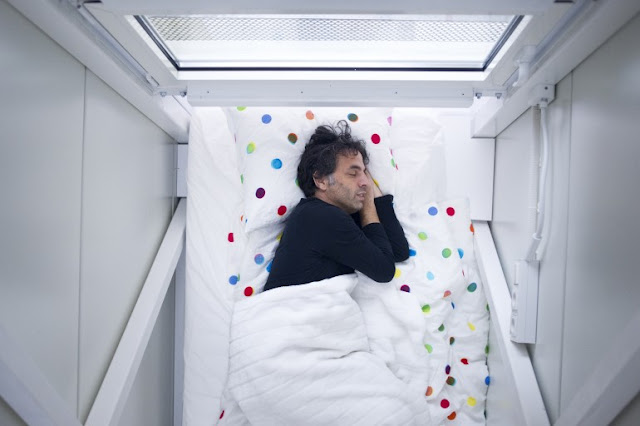 Picture of Keret sleeping in his bed in the bedroom of world's narrowest house
