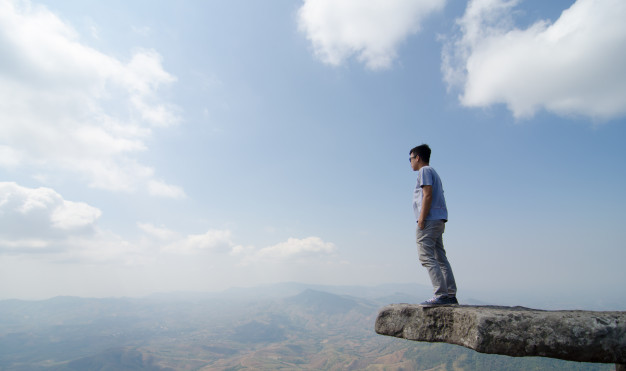 young-happy-man-standing-cliff-s-edge-phu-buk-dai-mountain-loei-province-has-steep-popular-destinations_5207-74