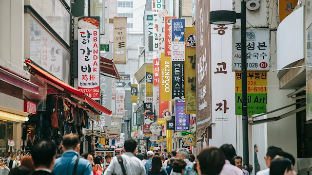 Suasana ramai di Myeongdong, Seoul, dengan kerumunan orang yang berdesakan di jalanan belanja populer