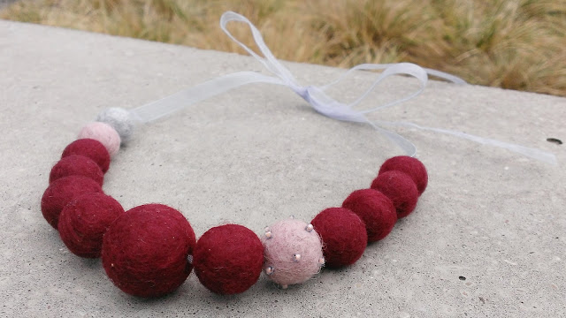 Red felted necklace with ribbon close-up