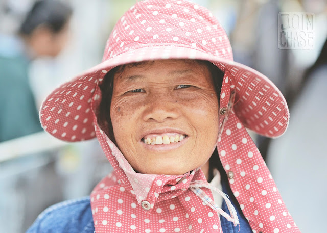 A Thai woman with a wide grin by the area where Thailand, Laos, and Myanmar meet. 
