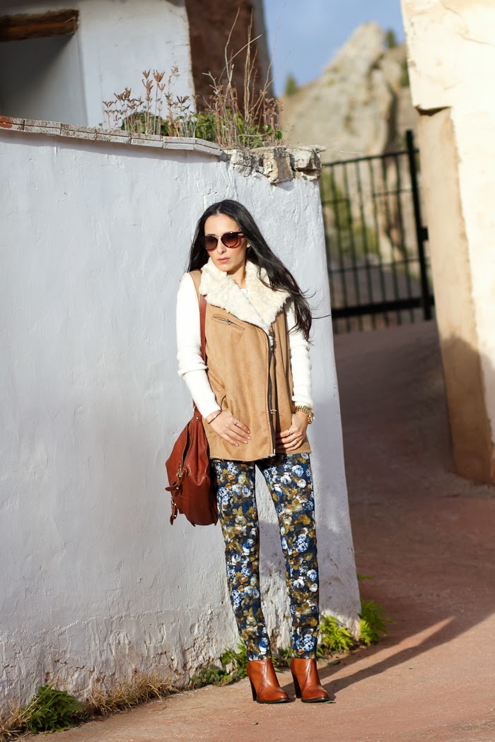 Fashion Blogger con chaleco de pelo, pantalones de flores azules y mostaza de neopreno y botines de Zara