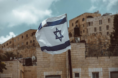 Israeli flag flying in Jerusalem (Credit: Taylor Brandon/Unsplash)