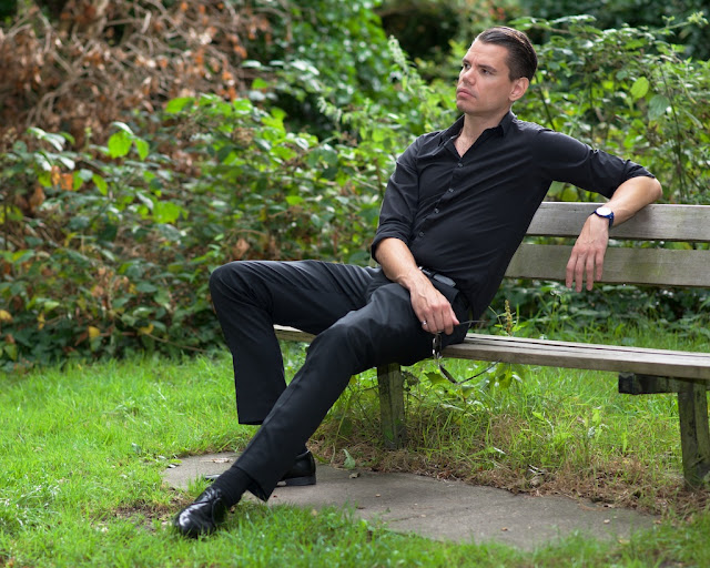 shirt and trousers seated on a bench