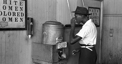 Man drinking water during Jim Crow era