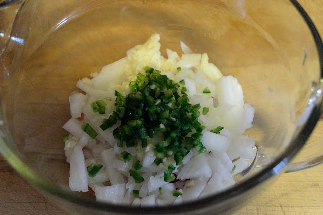 Minced jalapeno, garlic, and diced onion in a mixing bowl.