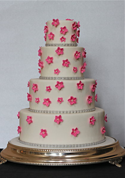 Their wedding cake was decorated with hot pink sugar blossoms and rhinestone