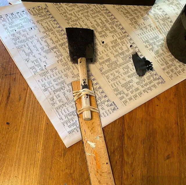 Photo of a sponge brush attached to a ruler with rubber bands