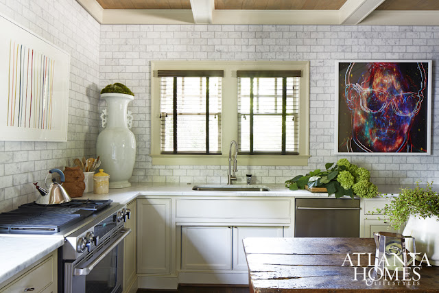 White eclectic kitchen with stainless appliances and modern art