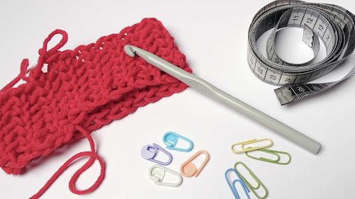 crochet sample, hook, measurement tape, stitch markers