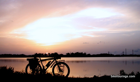 Picture of touring bike with sunset over bay