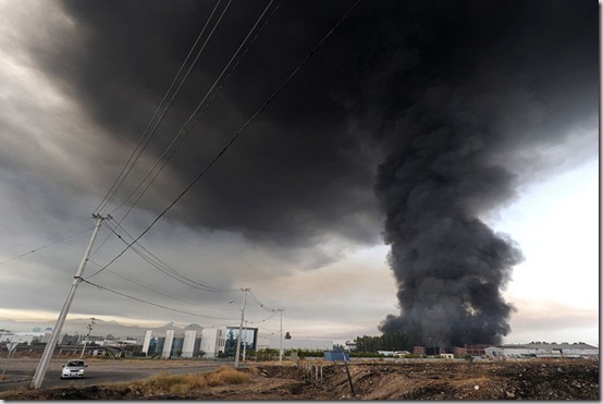 Smoke from a burning building fills the sky in the outskirts of Santiago after a huge 8.8-magnitude earthquake rocked Chile early killing at least 78 people, on February 27, 2010. The massive quake plunged much of the Chilean capital, Santiago, into darkness as it snapped power lines and severed communications, and AFP journalists spoke of walls and masonry collapsing. People in pyjamas fled onto the streets. AFP PHOTO/MARTIN BERNETTI (Photo credit should read MARTIN BERNETTI/AFP/Getty Images)
