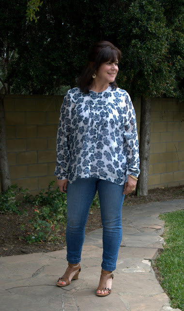 skinny jeans and floral blouse with wedge sandals.