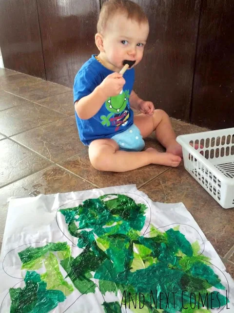 Toddler doing bleeding tissue paper art project for St. Patrick's Day