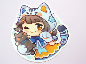 A sticker of a chibi-style character dressed as a cat/neko