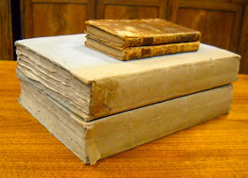 A stack of books, two large and two small.