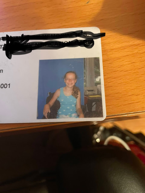 Old ID photo of me at age 12. I am a white young woman in a wheelchair with a blondish ponytail, glasses, and an aqua tank top.