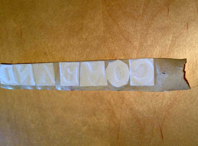 iron-on letters cut out and attached to masking tape