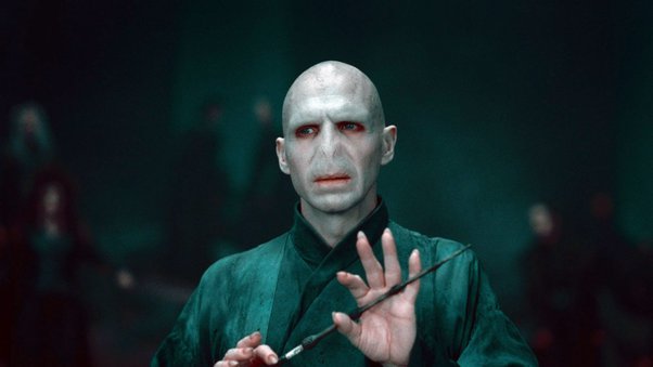 Voldemort is holding a wand on his hands and looking at someone infront of him.