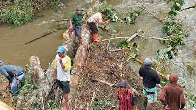 Bhabinkamtibmas Bulan Jaya Bersihkan Sungai Dari Tumpukan Kayu