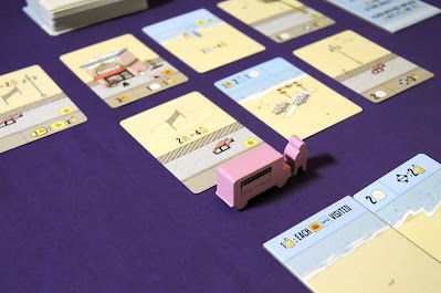 Pink food truck and foodie meeples incentivizing one card on display in Santa Monica boardgame