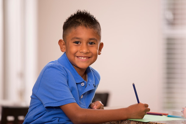 Following the child in the public school system. Smiling student working in classroom