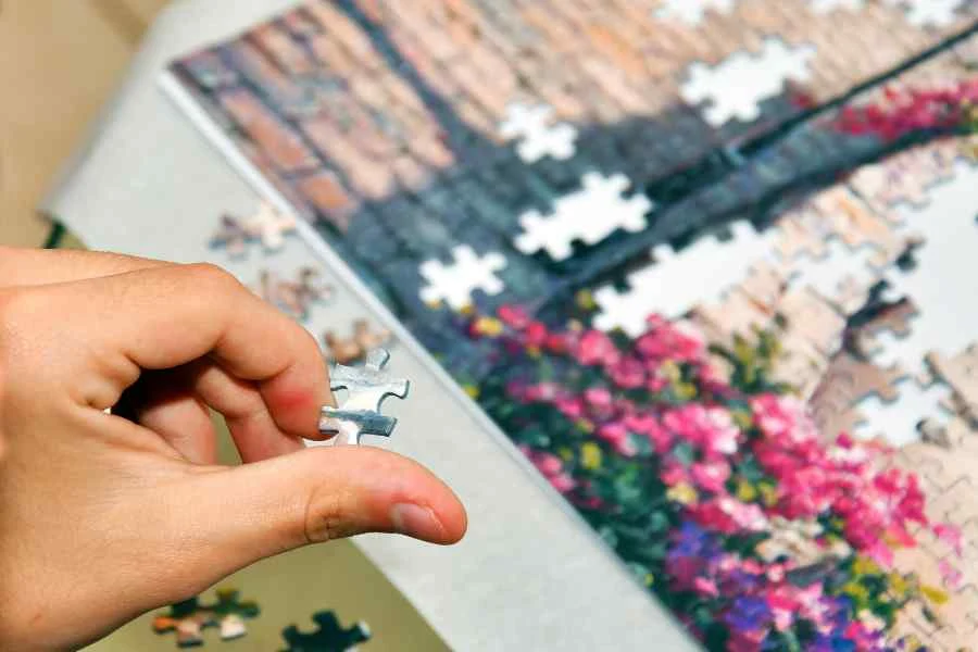 A person completing a jigsaw in a stock image from canva pro