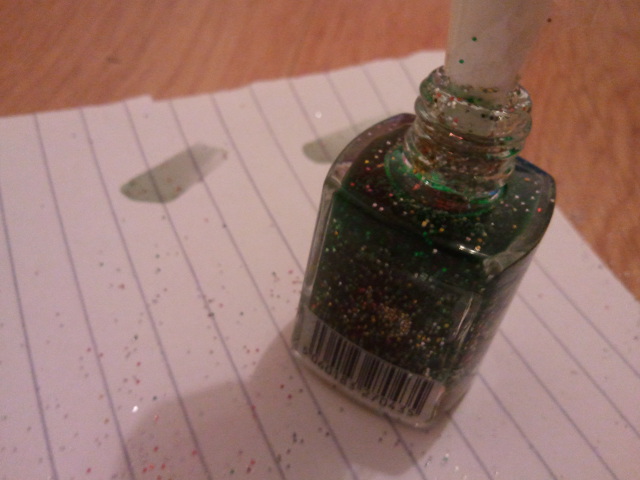 Nail varnish bottle with green as prominent colour in top half but all shades of glitter throughout