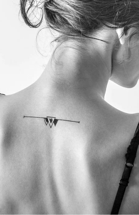 Chica mostrando tatuaje en forma de triángulos que se encuentra en su espalda